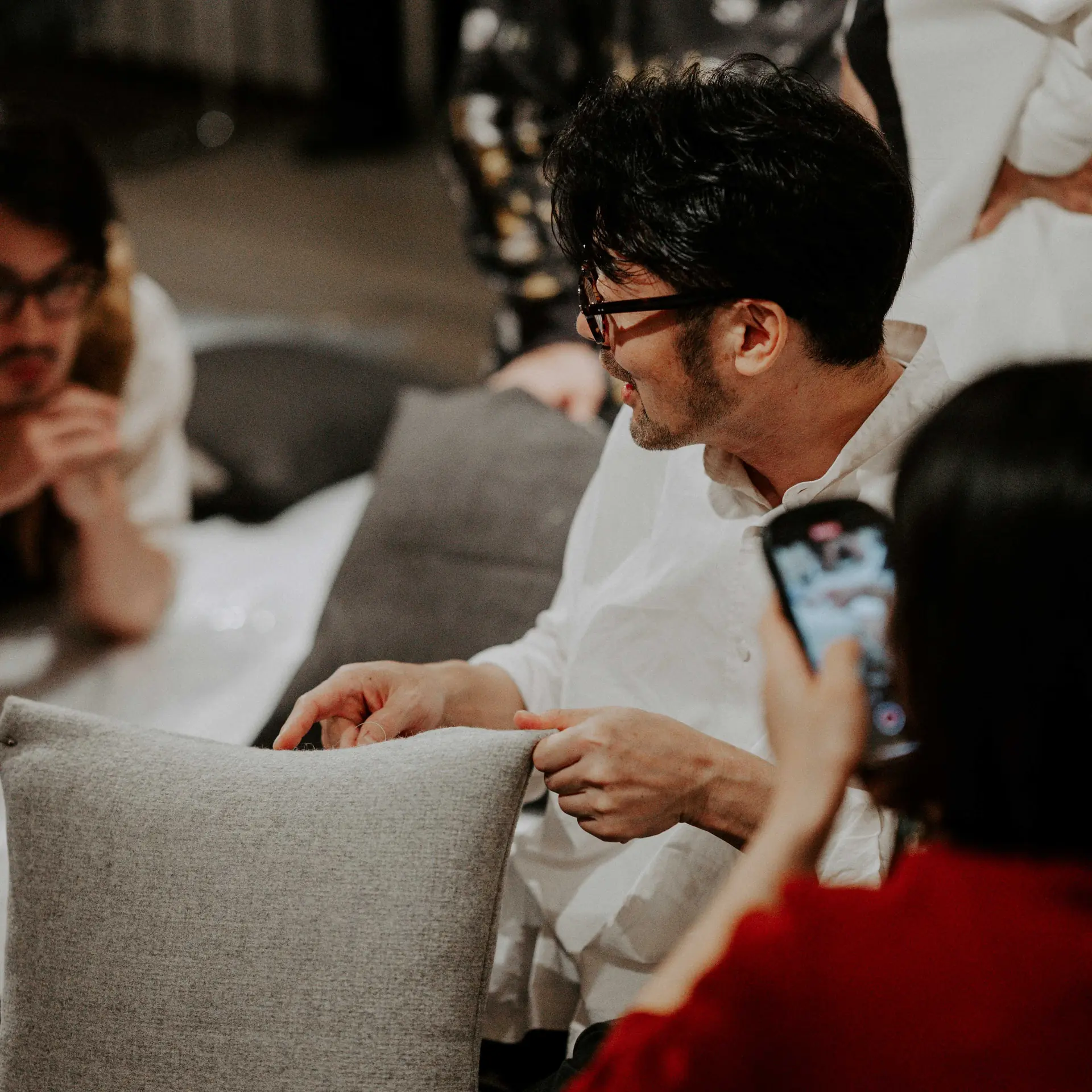 Takuya Niwa at work, in conversation across a piece of furniture.