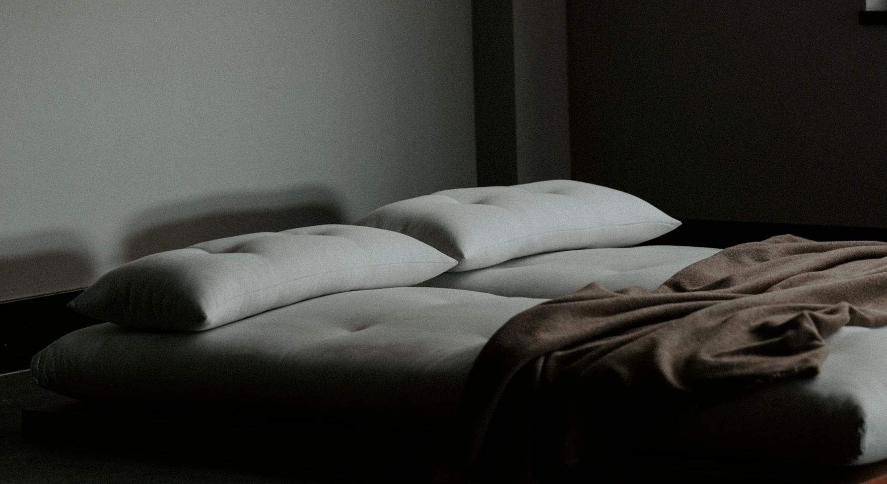 Bedding made for a collaborative project, laid out in a quiet, dimly lit room.