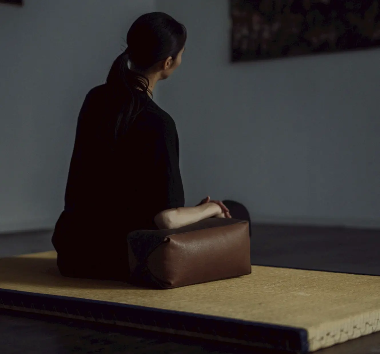 A person seated on the floor beside a KYO-SOKU armrest.