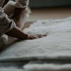 Hands preparing raw cotton